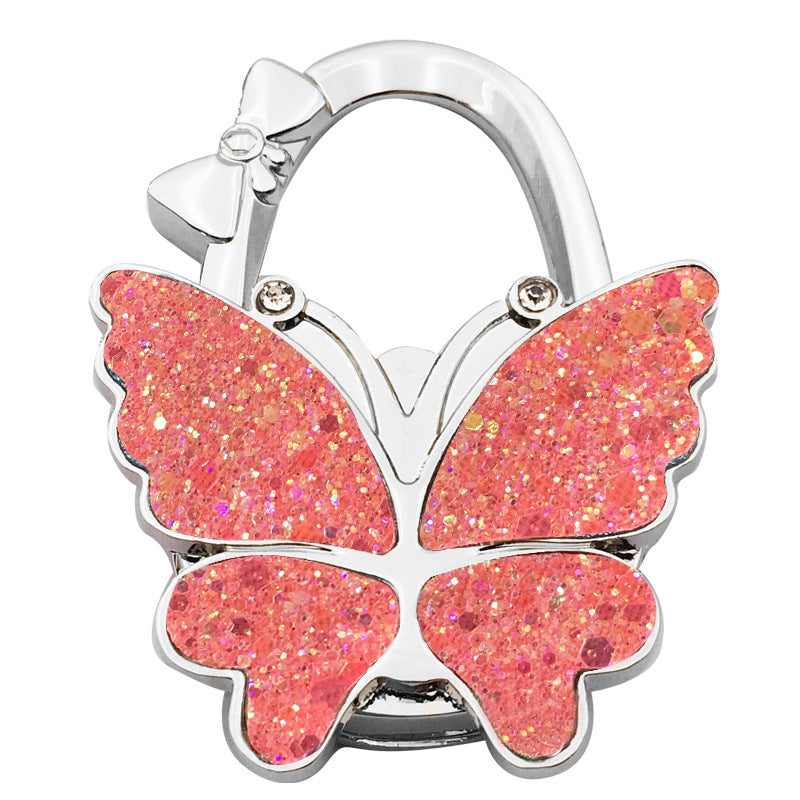 🦋👜【Compra uno y llévate otro gratis】Gancho plegable para bolso con forma de mariposa colorida