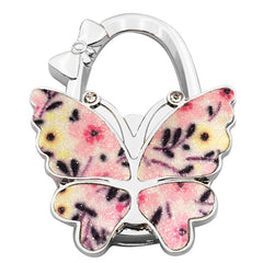 🦋👜【Compra uno y llévate otro gratis】Gancho plegable para bolso con forma de mariposa colorida