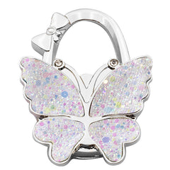 🦋👜【Compra uno y llévate otro gratis】Gancho plegable para bolso con forma de mariposa colorida