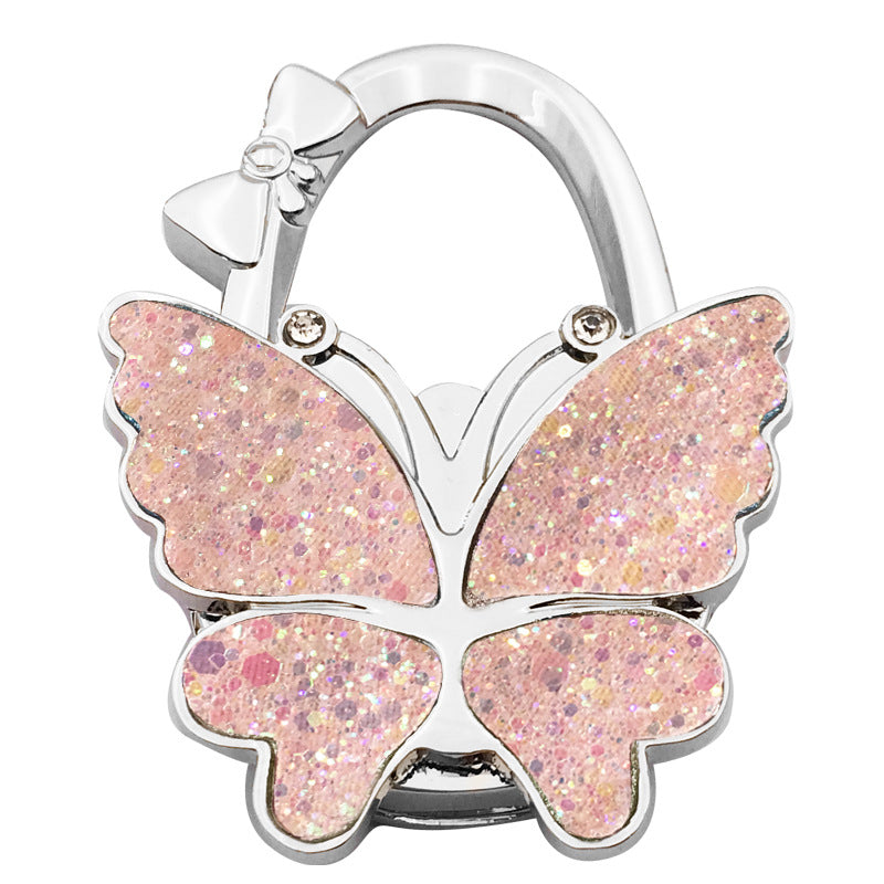 🦋👜【Compra uno y llévate otro gratis】Gancho plegable para bolso con forma de mariposa colorida