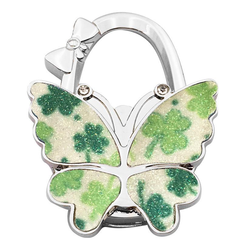 🦋👜【Compra uno y llévate otro gratis】Gancho plegable para bolso con forma de mariposa colorida